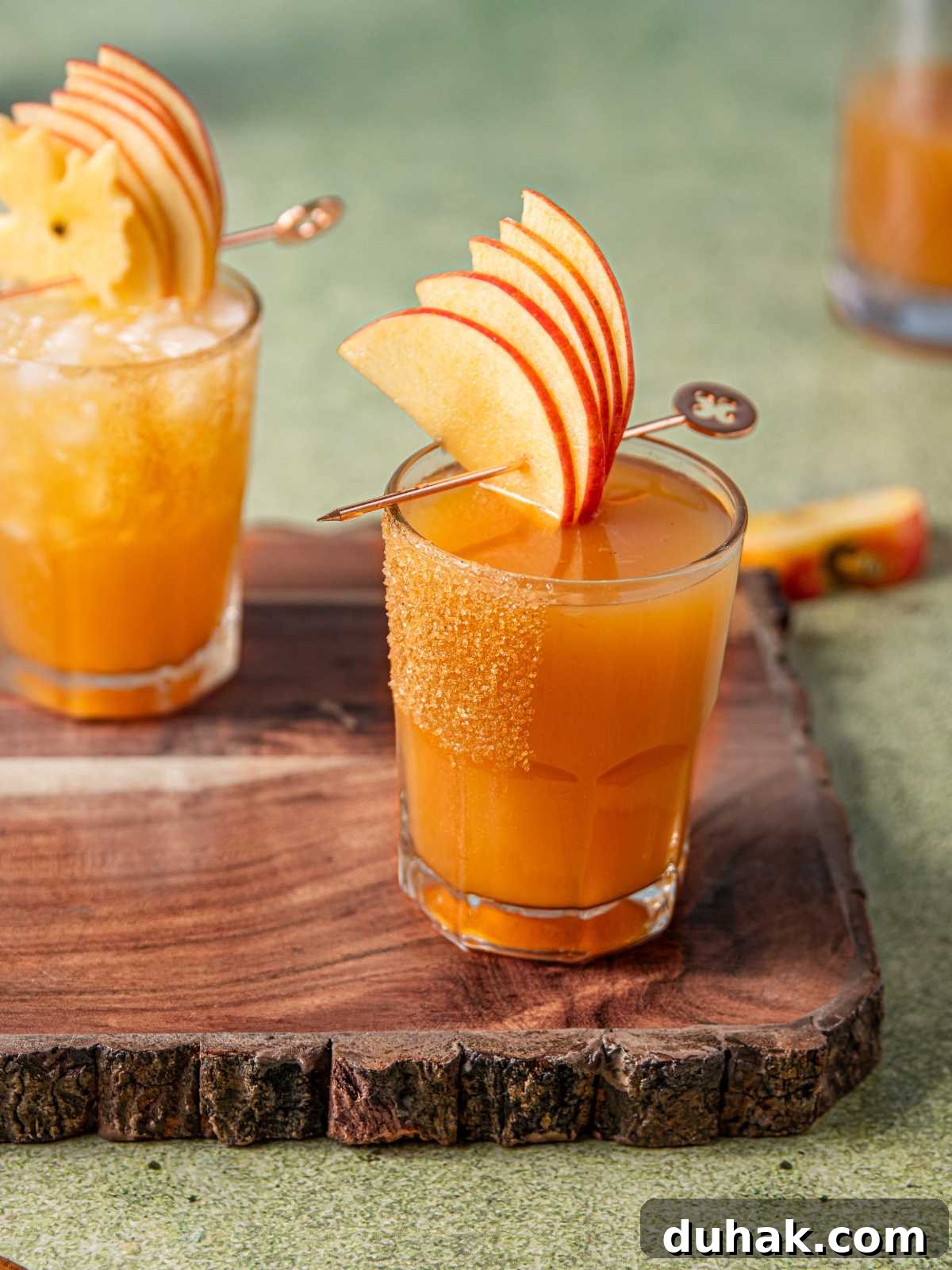 Bourbon apple cider cocktail garnished with apple slices.