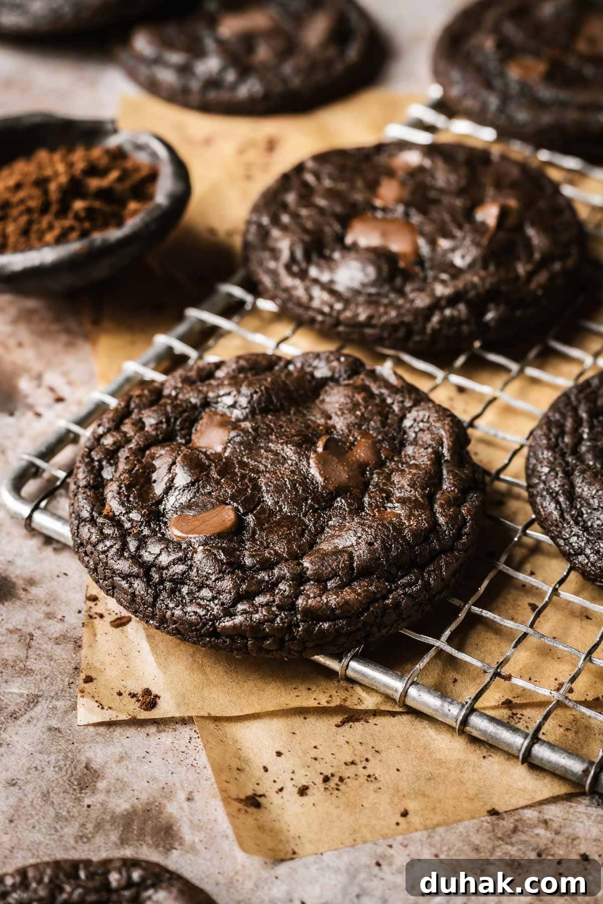 Double Cocoa Chocolate Cookies: Rich, Soft Baked Treats 15 Chocolate cookies with cocoa powder on a vintage metal cooling rack.