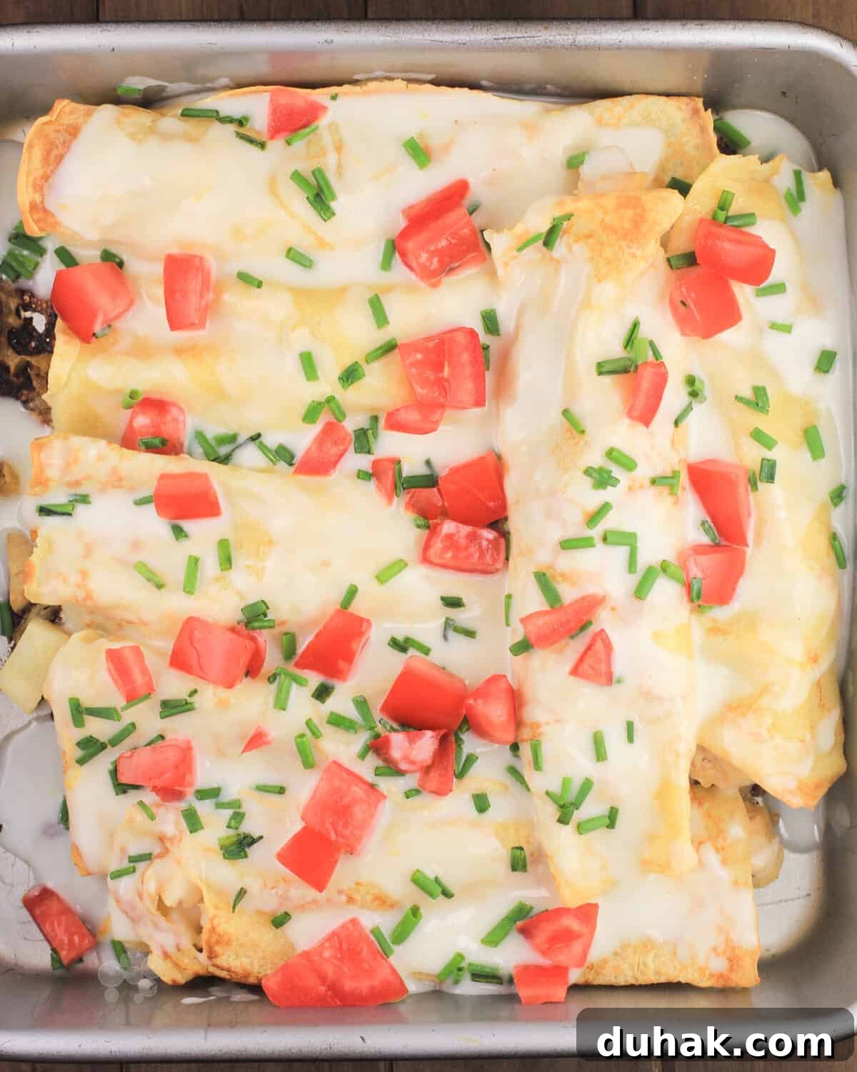 Savory Chicken and Potato Crepes: Rustic Filling Recipe 10 crepes in bake pan covered with lemon bechamel sauce, tomato, and chives