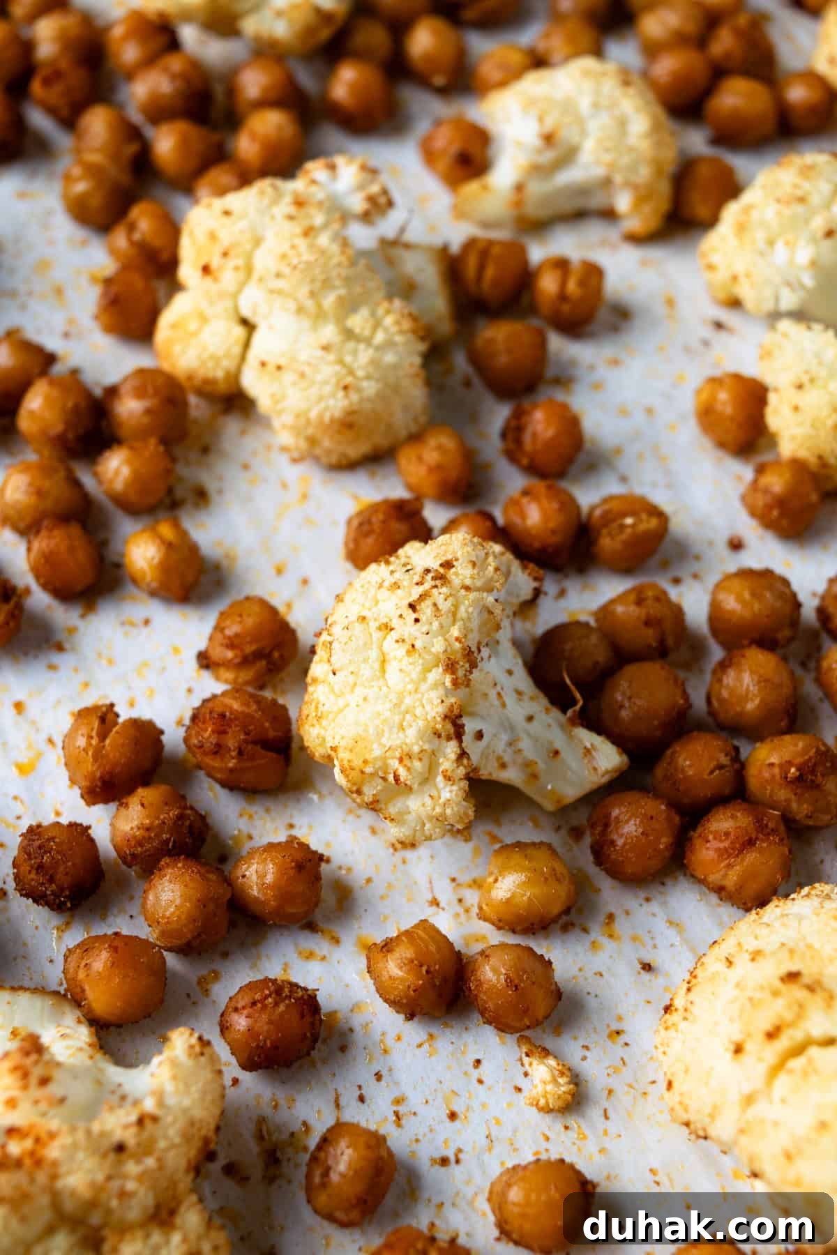 Roasted Cauliflower and Chickpeas on a parchment lined baking sheet.