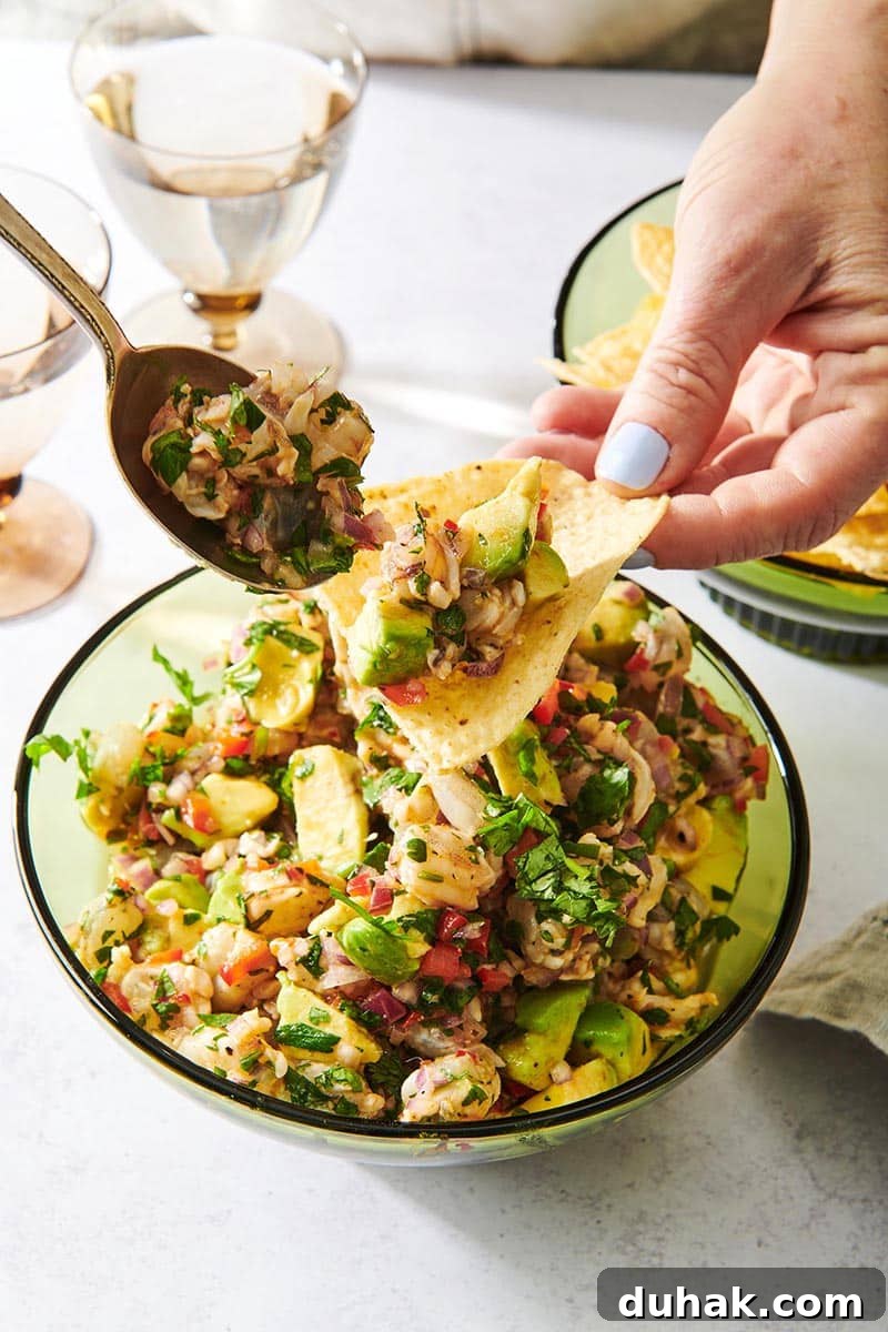 Spoon putting Shrimp Ceviche onto a tortilla chip.