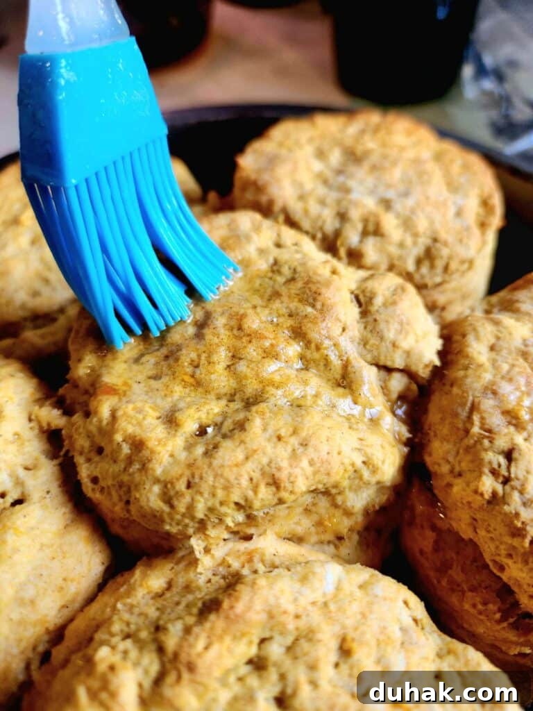 brushing butter on a sweet potato biscuit