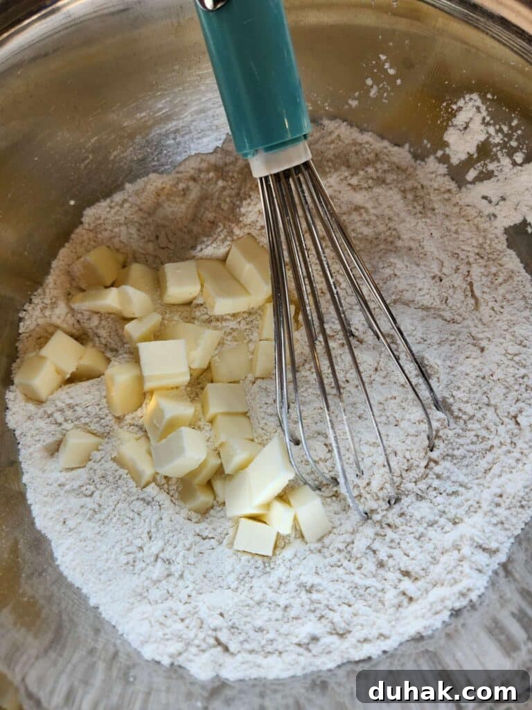 adding cut butter to biscuit dough