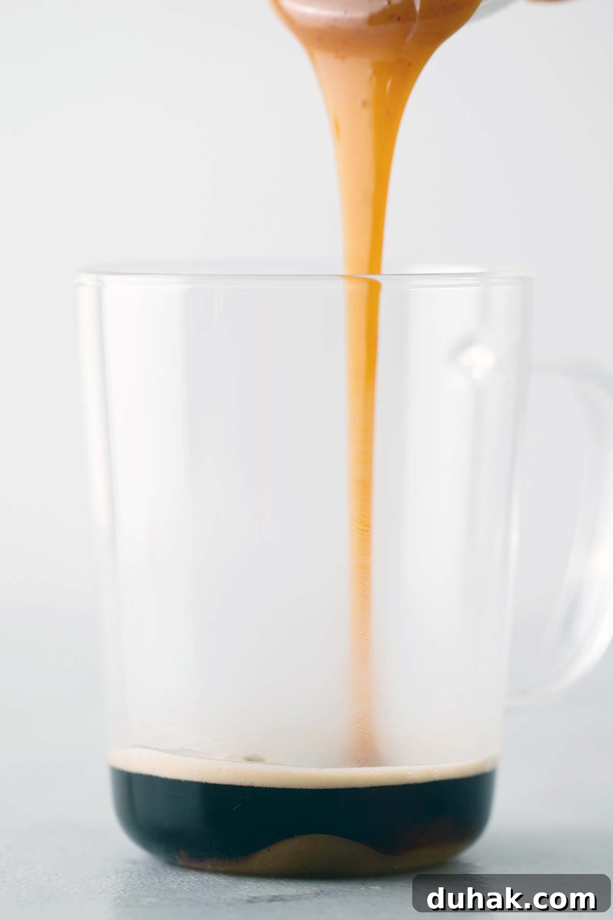 Pumpkin Spice Latte Recipe: How to Make a Cozy Fall Coffee 6 Pouring pumpkin spice sauce into espresso.