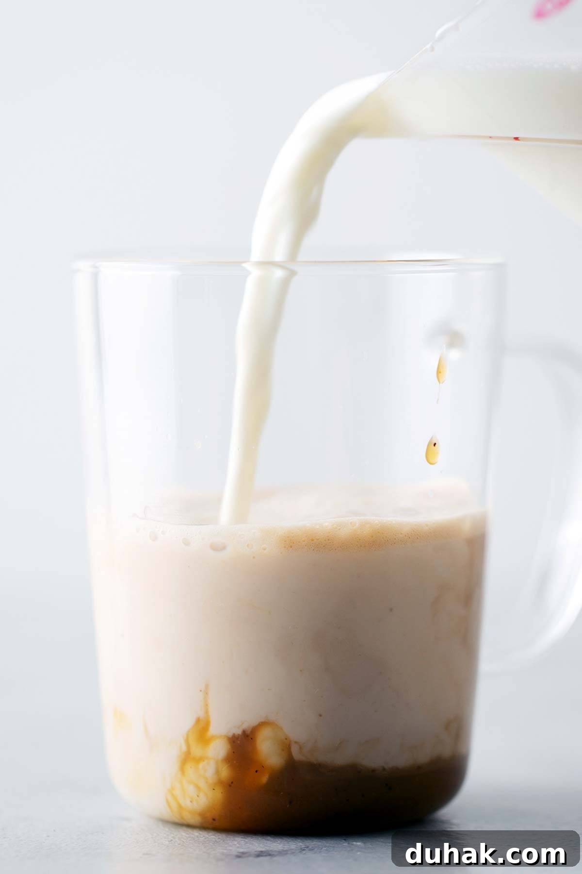 Pumpkin Spice Latte Recipe: How to Make a Cozy Fall Coffee 7 Pouring frothed milk into a cup of espresso.