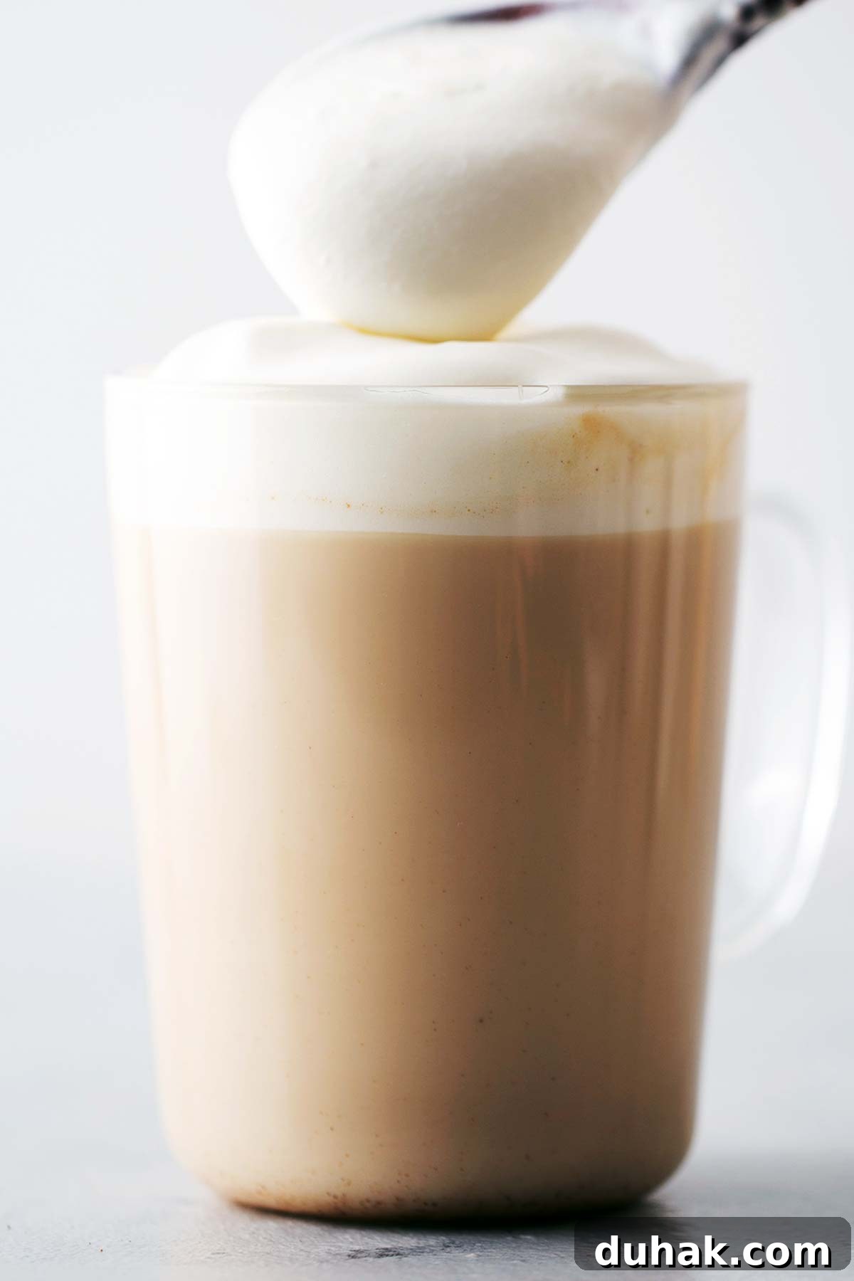 Pumpkin Spice Latte Recipe: How to Make a Cozy Fall Coffee 8 Topping a drink with whipped cream.
