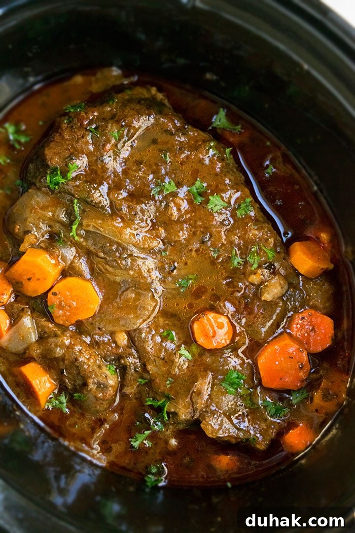 Chuck Roast in Black Slow Cooker With Gravy.