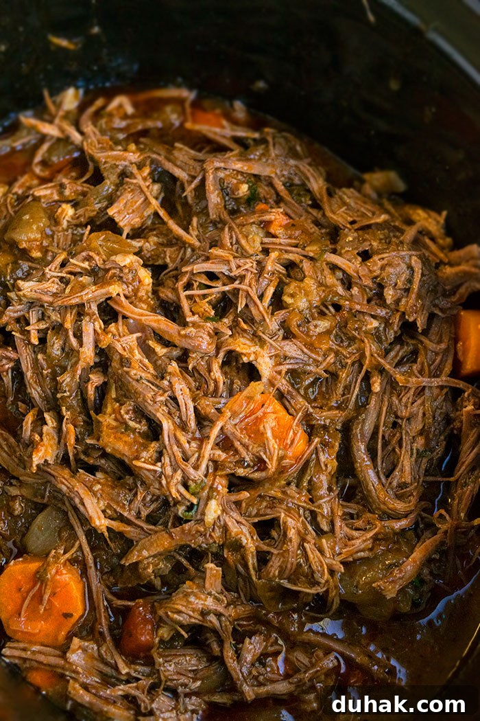 Shredded Roast with Potatoes and Carrots in Black Crockpot.