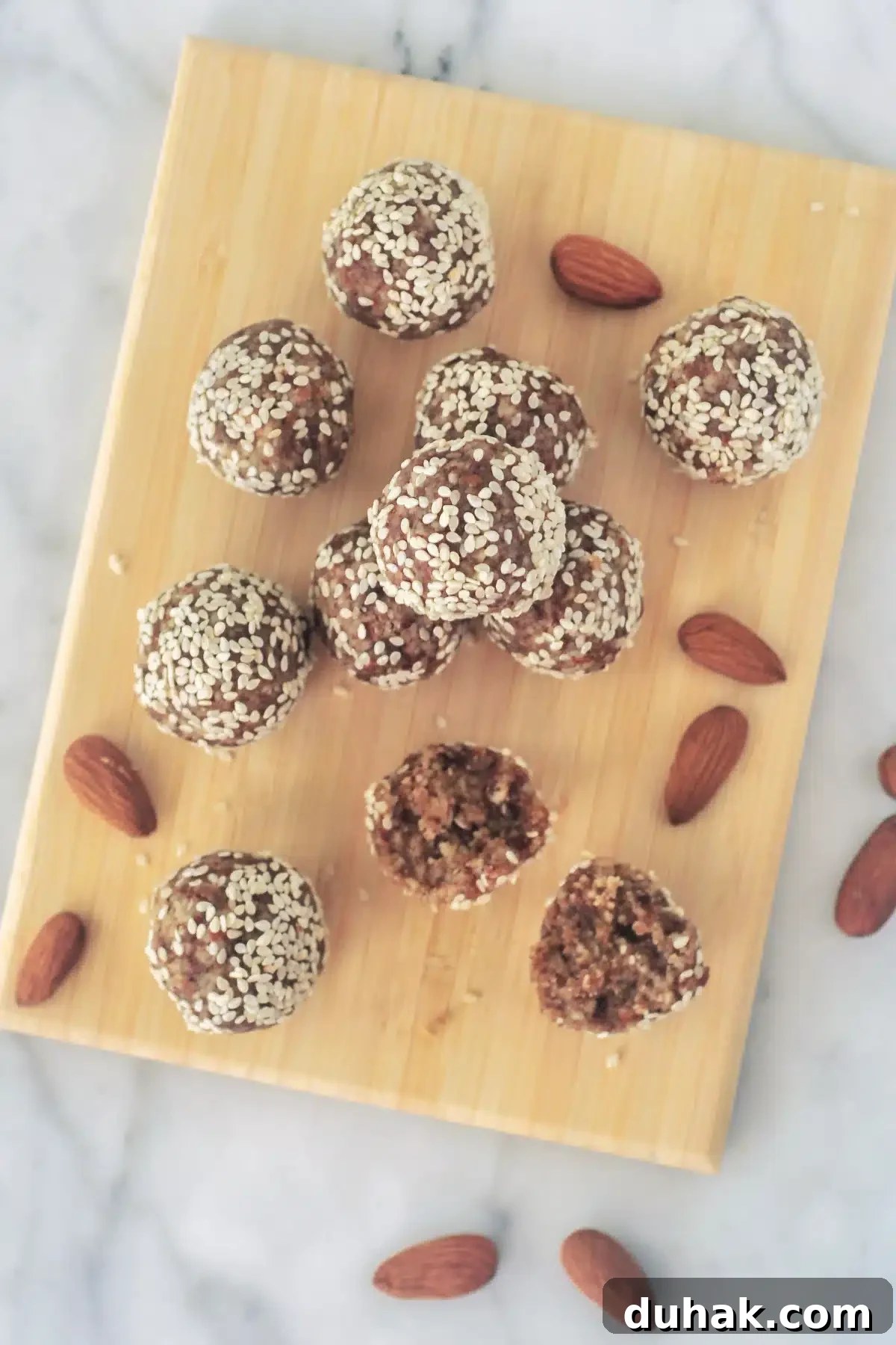 Tahini Almond Date Bites Overhead view of tahini almond date balls on a small bamboo board.