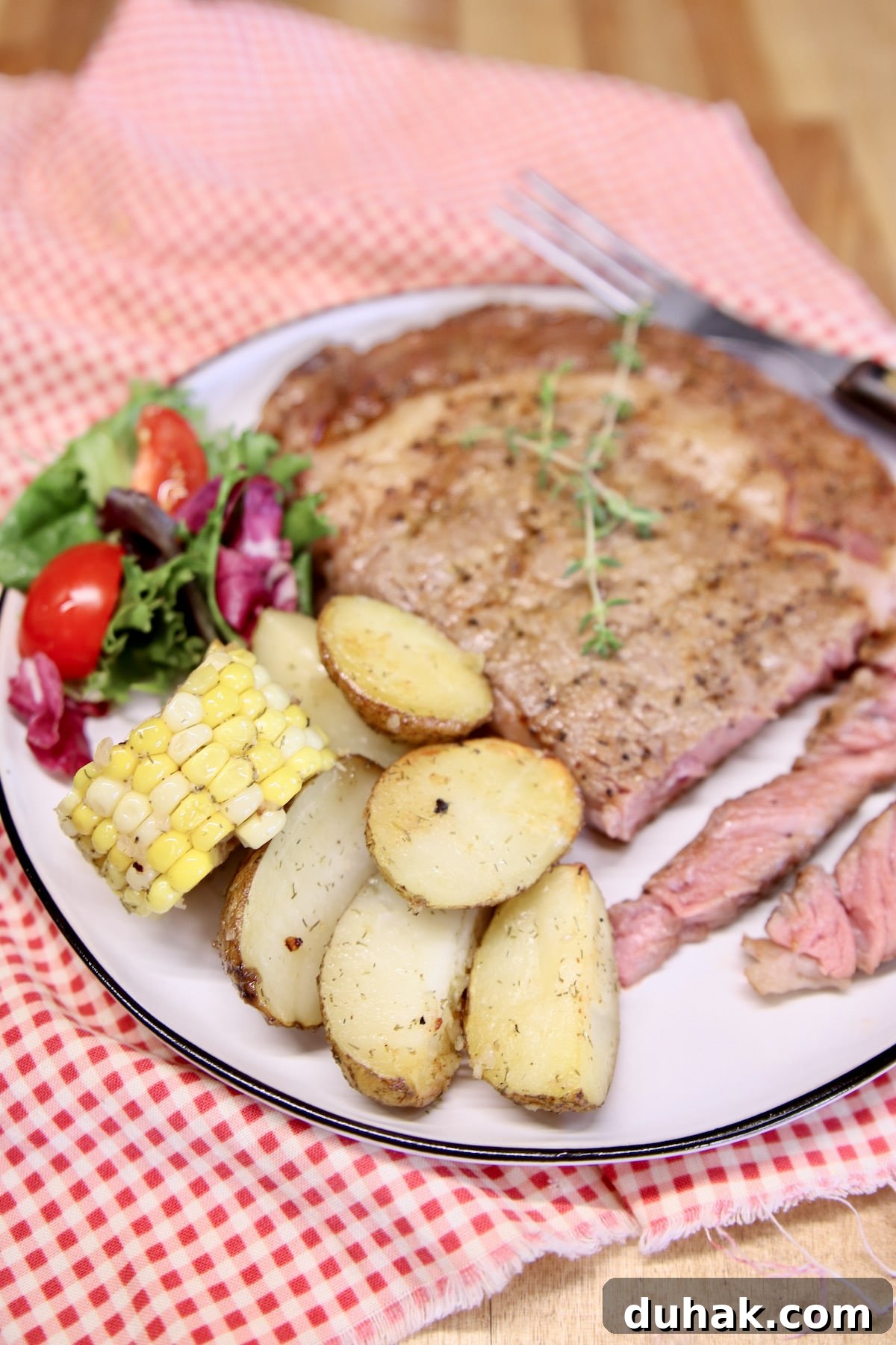 Steak, potatoes and corn on a plate.