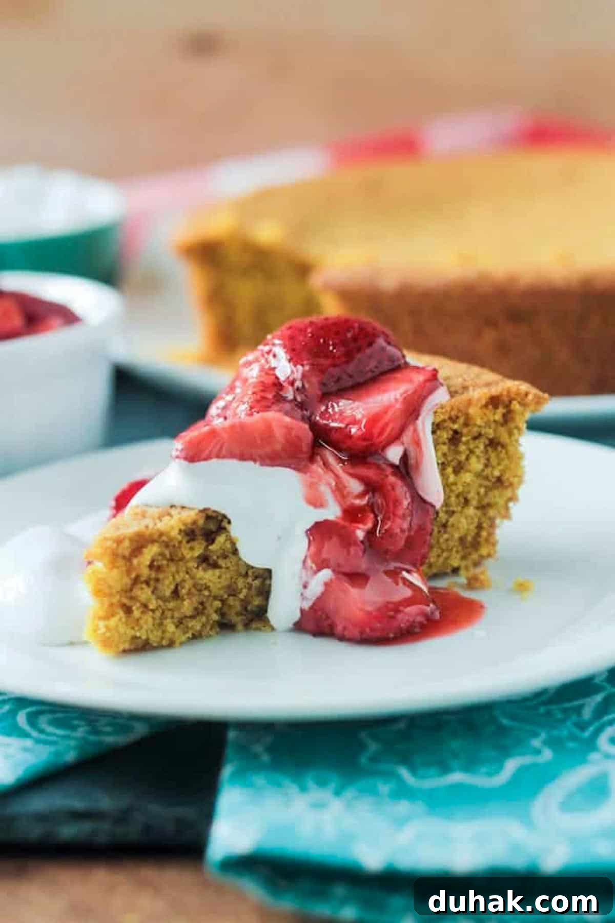 Vanilla Corn Cake w/ Roasted Strawberries. Just sweet enough with a lovely crumbly texture you expect from cornbread. Vanilla cornbread cake topped with strawberries and whipped cream.