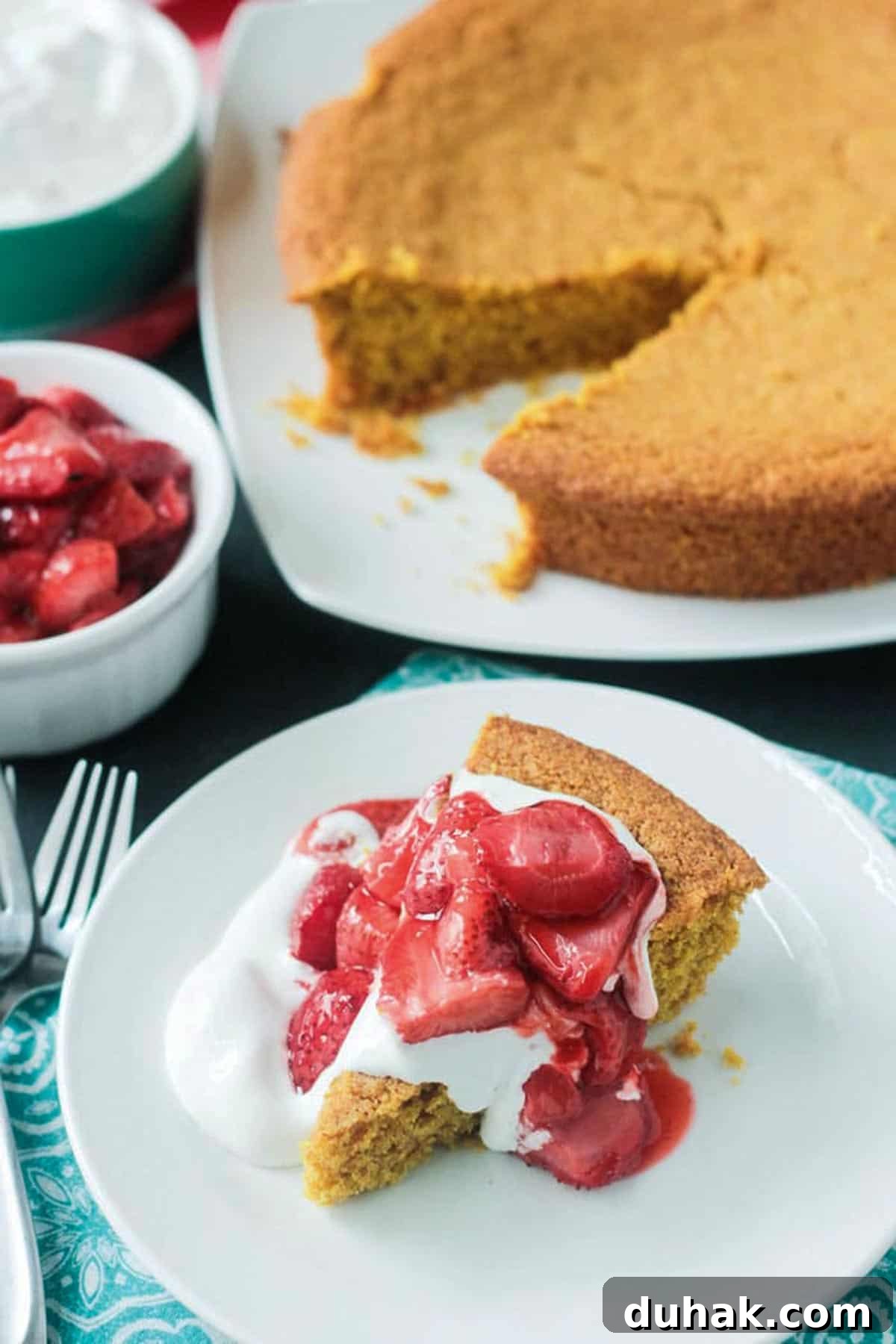 Vanilla Cornbread Cake Recipe: Moist, Sweet Corn Cake 7 Slice of cake on a white plate with the rest of the cake behind.