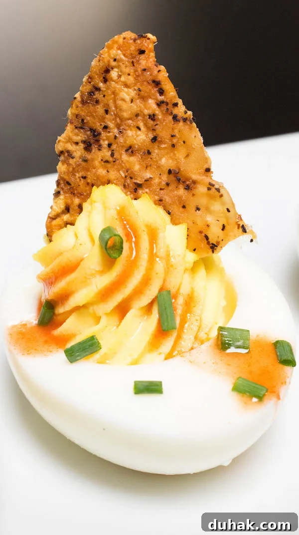 A Deviled Egg with Fried Chicken Skin & Hot Sauce.